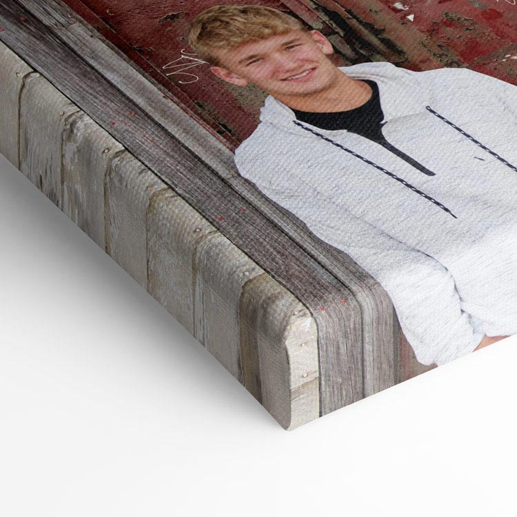 Close-up of a canvas print featuring a portrait of a smiling young man, showcasing the texture and wrapped edges of the canvas