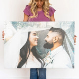Woman holding a large custom canvas print of a smiling bride and groom