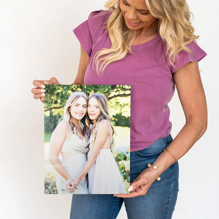 Woman holding a custom metal print, showcasing high-quality photo reproduction