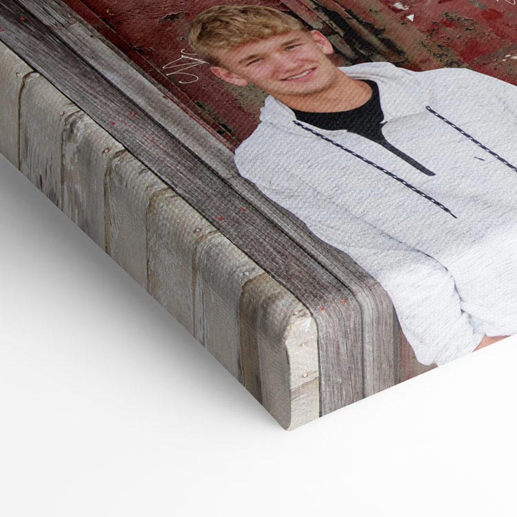 Close-up of a canvas print featuring a portrait of a smiling young man, showcasing the texture and wrapped edges of the canvas