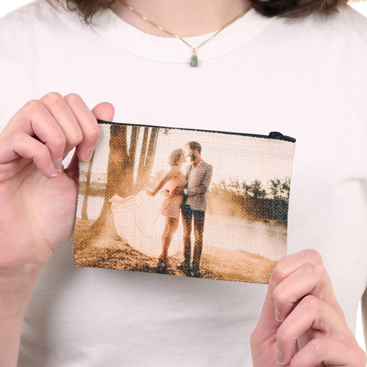 Girl holding a custom zippered coin purse pouch featuring a romantic photo of a couple printed on textured linen fabric